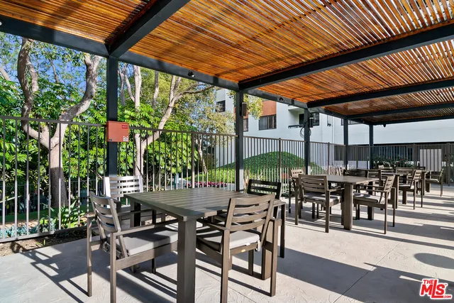 a view of a patio with table and chairs under an umbrella with a patio