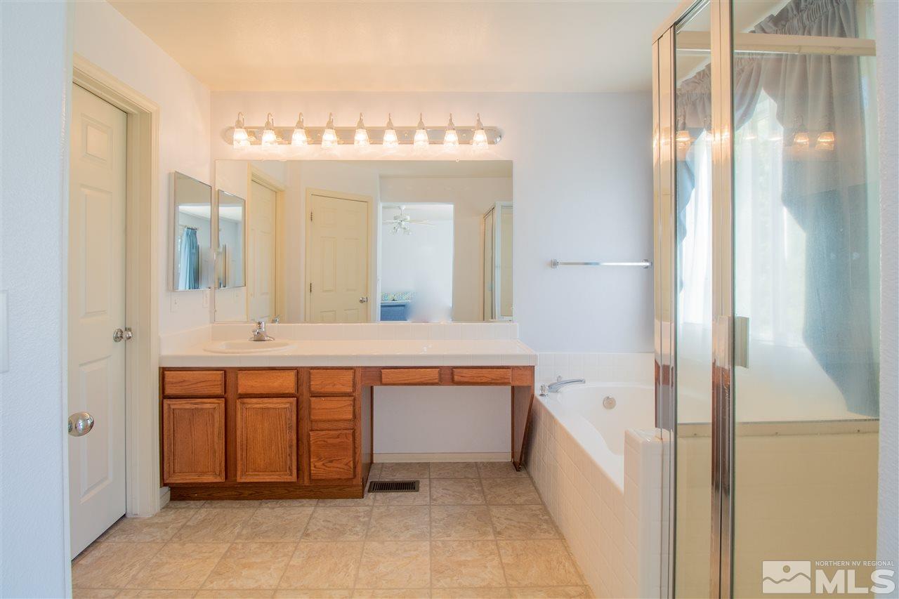 4027 Kings Row Reno, NV 89503 - Photo 8 of 17 a spacious bathroom with a mirror a sink and bathtub
