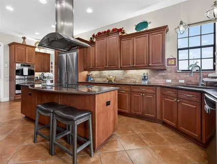 a bathroom with a granite countertop double vanity sink a bathtub a mirror and vanity