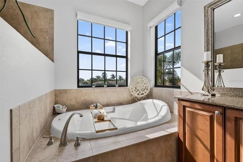 a bathroom with a granite countertop sink a mirror and shower
