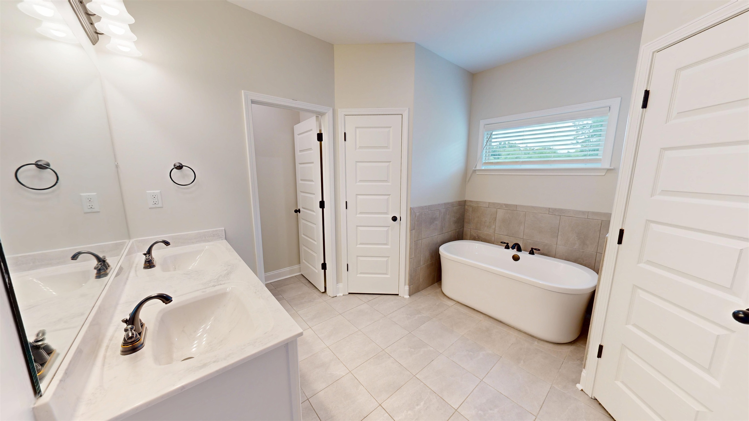 5217 Nail Road Olive Branch, MS 38654 - Photo 16 of 35 Bathroom featuring a freestanding bath, double vanity, light tile patterned floors, and tile walls