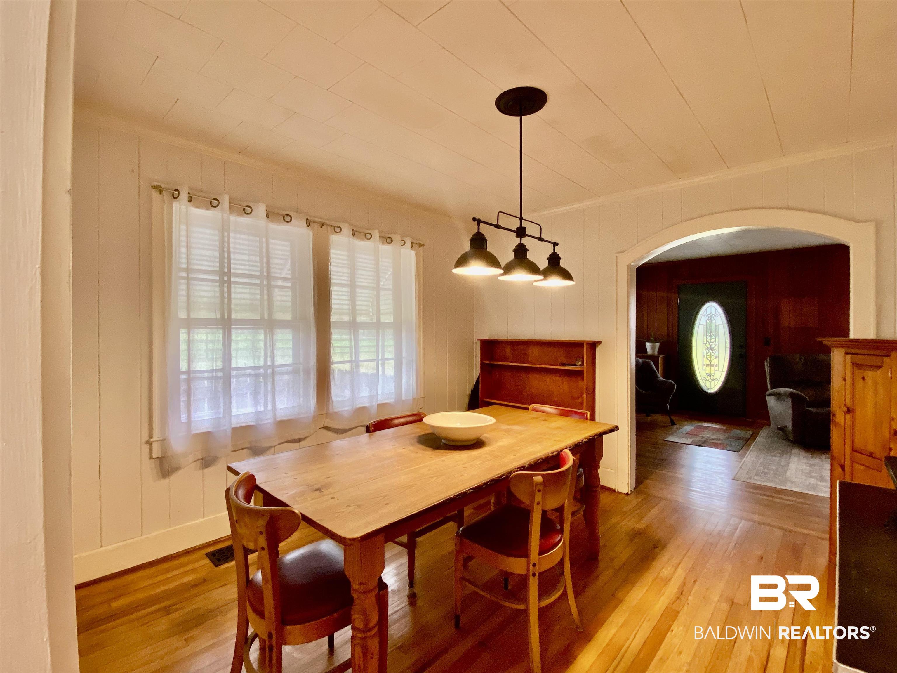 770 Arena Road Frisco City, AL 36445 - Photo 16 of 51 Dining space featuring light wood-style flooring, visible vents, arched walkways, and ornamental molding