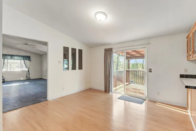 a kitchen with stainless steel appliances kitchen island granite countertop a refrigerator a stove a sink dishwasher and white cabinets with wooden floor