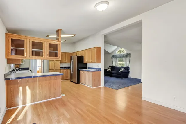 a kitchen with a refrigerator a sink and dishwasher with wooden floor