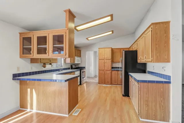 a kitchen with stainless steel appliances granite countertop a stove a sink and a refrigerator