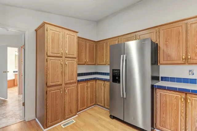 a kitchen with stainless steel appliances granite countertop a refrigerator and a stove top oven