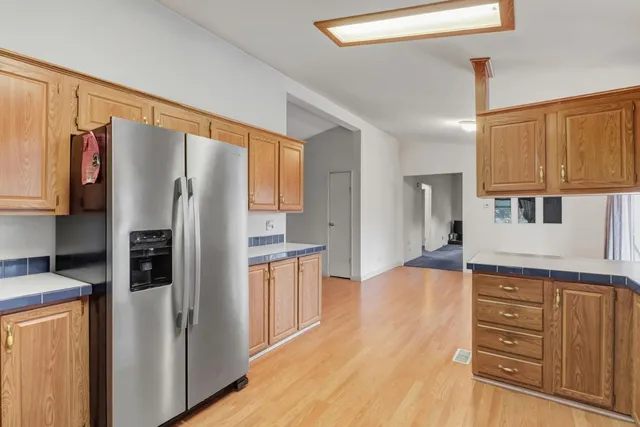 a kitchen with stainless steel appliances granite countertop a sink a stove cabinets and wooden floor