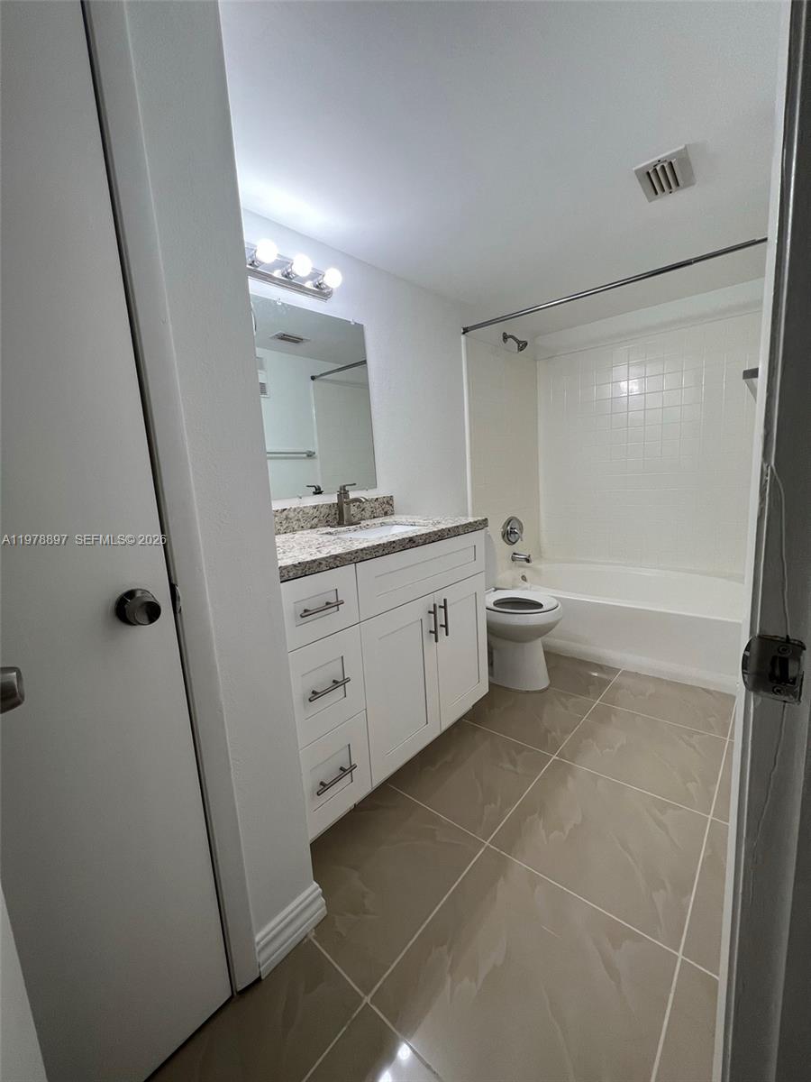 15581 Southwest 104th Terrace, Unit 224 Miami, FL 33196 - Photo 12 of 18 a spacious bathroom with a double vanity sink a toilet and a mirror