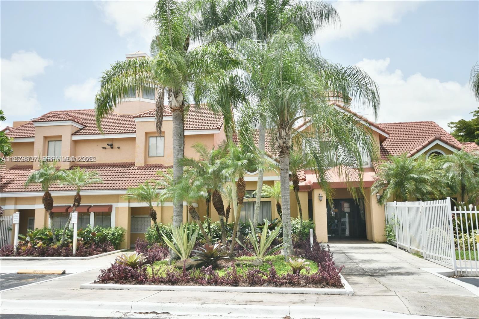 15581 Southwest 104th Terrace, Unit 224 Miami, FL 33196 - Photo 14 of 18 a front view of a building with garden view and trees