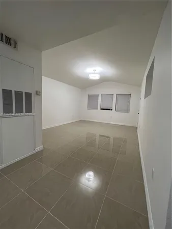 a view of a livingroom with an empty space and a window