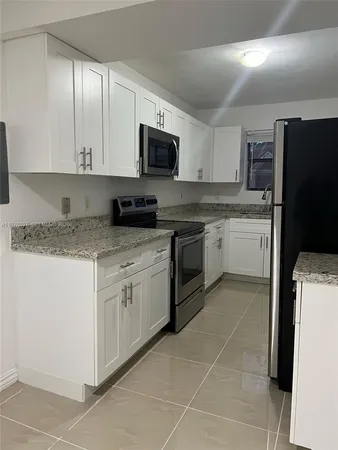 a kitchen with a sink stove and white cabinets