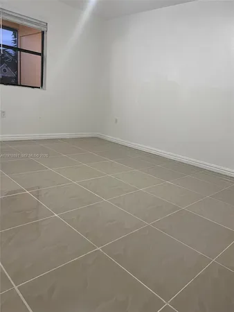 a bathroom with white tiles and a window