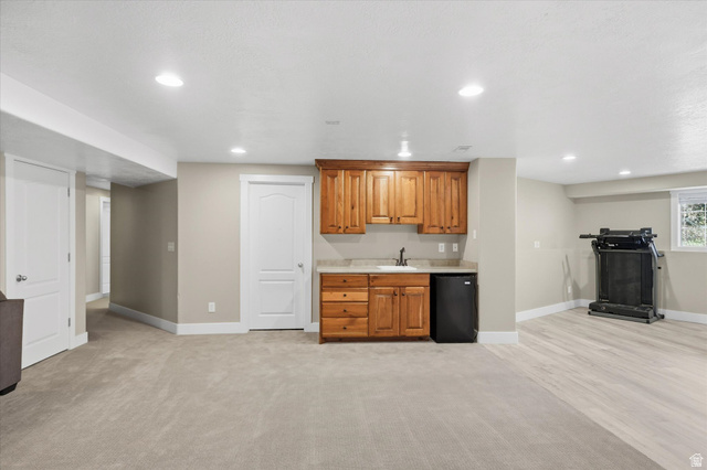 353 Robin Street Smithfield, UT 84335 - Photo 34 of 70 Indoor wet bar featuring wood finish cabinetry, black fridge, recessed lighting, and light carpet