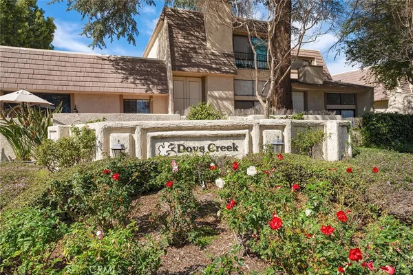 a view of a house with lot of flower plants