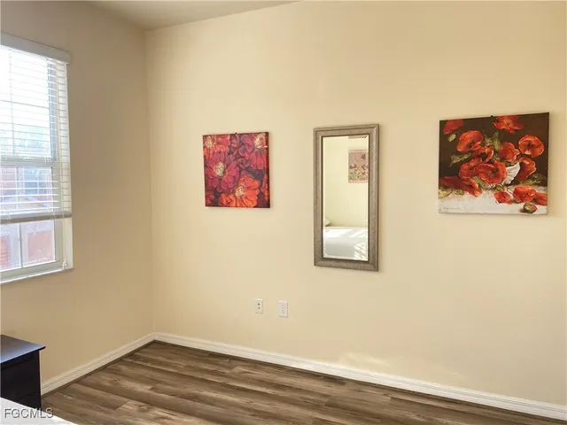 a view of a small space with wooden floor and a window