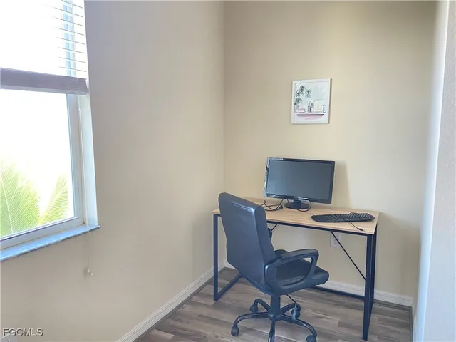 a view of a workspace with furniture and a window