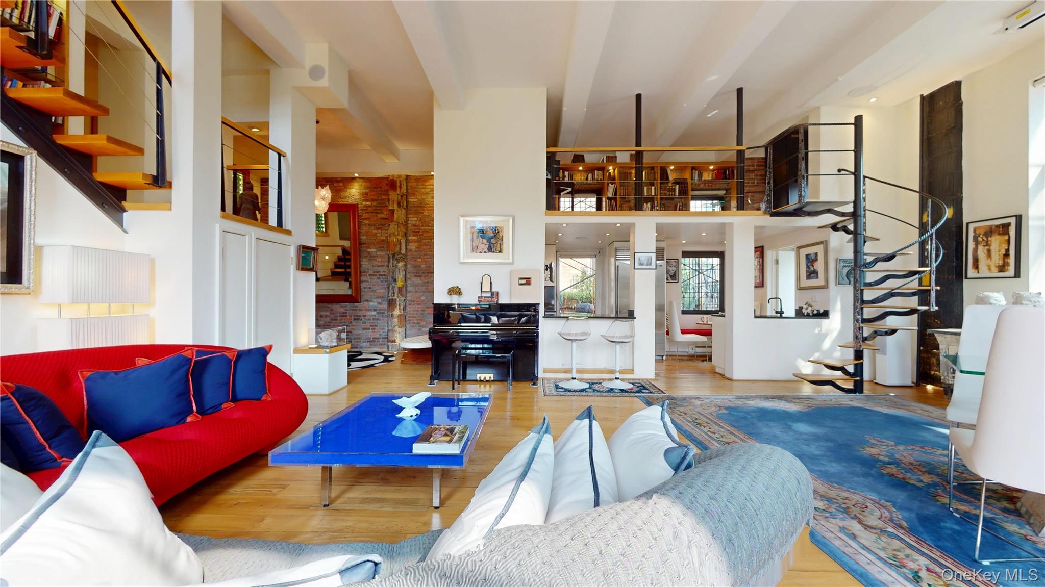 1255 5th Avenue Manhattan, NY 10029 - Photo 1 of 16 Living area with stairway, a high ceiling, wood finished floors, and brick wall