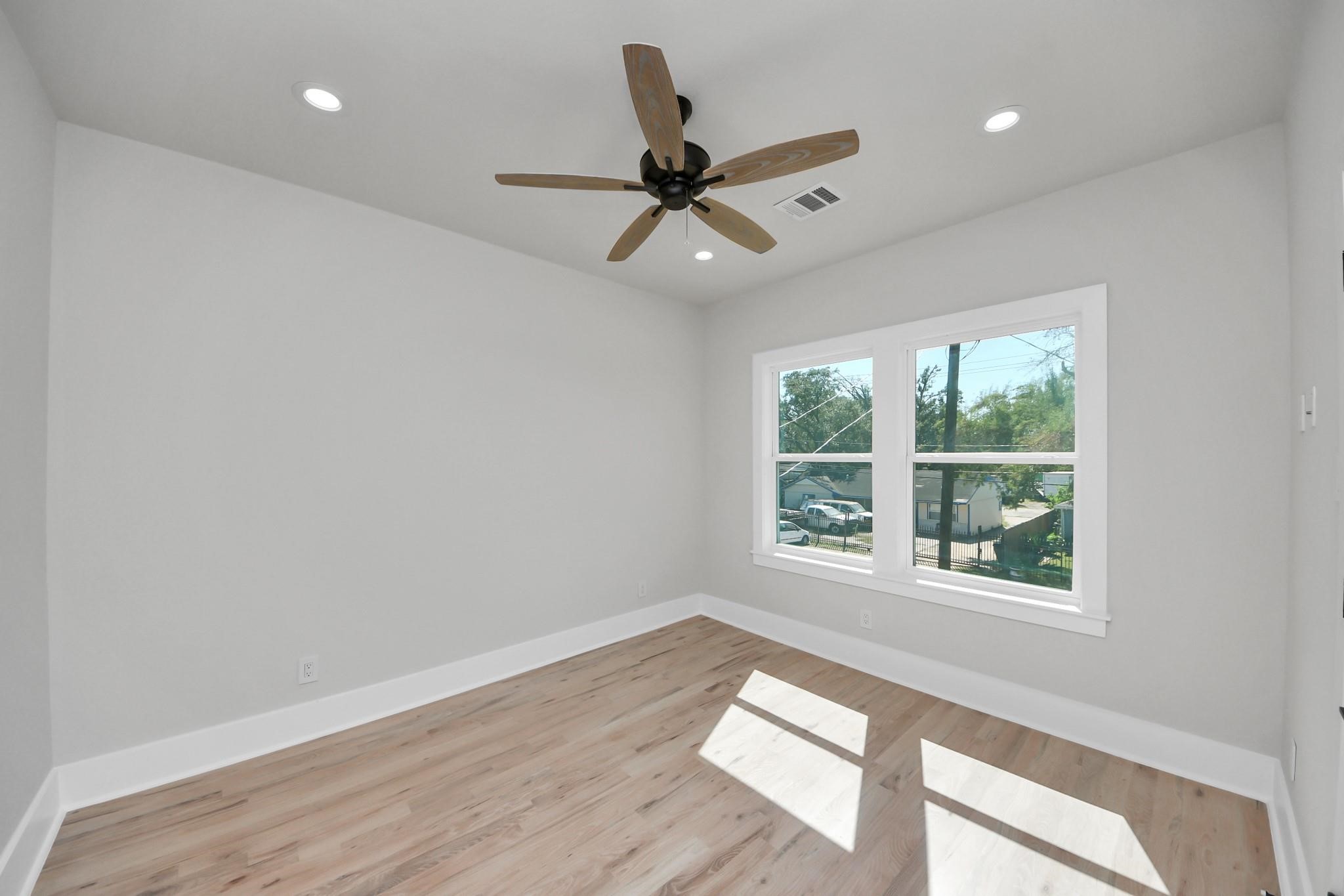 6320 Milwee Street, Unit B Houston, TX 77092 - Photo 13 of 30 a view of an empty room with wooden floor and a window