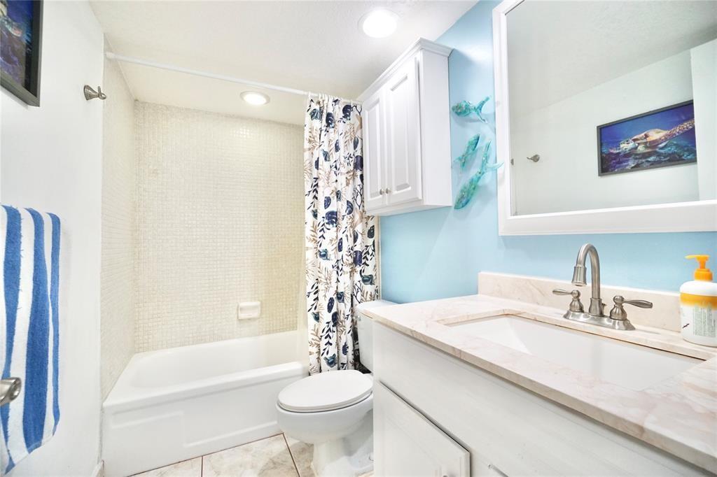 111 Briny Avenue, Unit 2307 Pompano Beach, FL 33062 - Photo 13 of 47 a bathroom with a sink a toilet a mirror a bathtub and shower