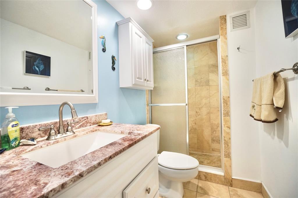 111 Briny Avenue, Unit 2307 Pompano Beach, FL 33062 - Photo 18 of 47 a bathroom with a granite countertop sink toilet and shower
