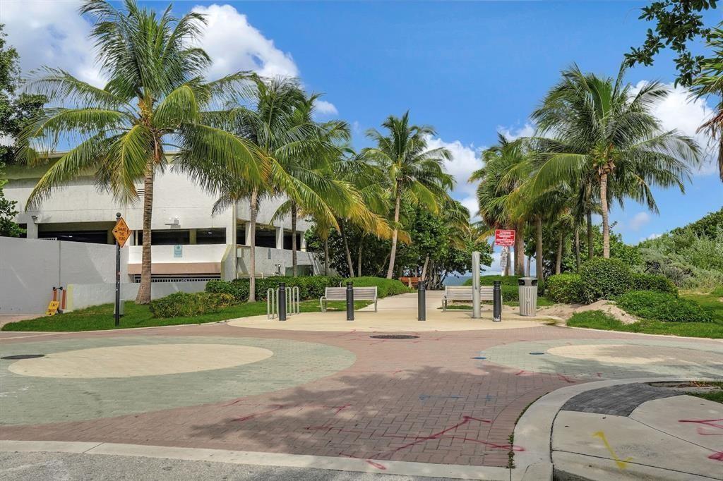111 Briny Avenue, Unit 2307 Pompano Beach, FL 33062 - Photo 44 of 47 a row of palm trees and a park on a road