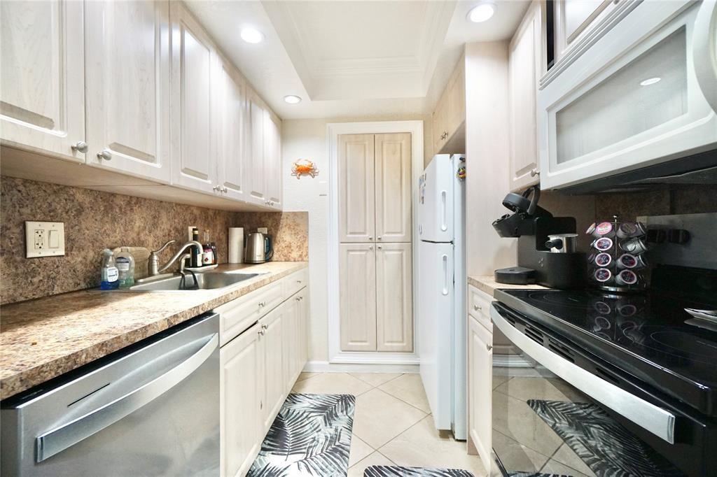 111 Briny Avenue, Unit 2307 Pompano Beach, FL 33062 - Photo 10 of 47 a kitchen with granite countertop stainless steel appliances a sink a stove and cabinets