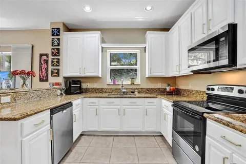 a kitchen with stainless steel appliances granite countertop a stove sink and cabinets