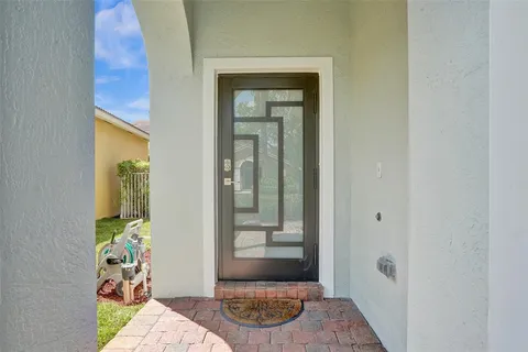 a view of a hallway with wooden floor and a bathroom