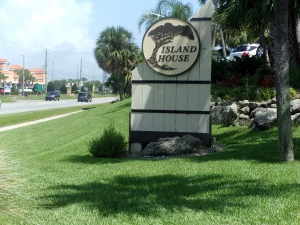 a sign board with a play ground in the back