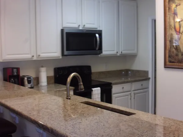 a kitchen with stainless steel appliances granite countertop a sink a microwave and stove