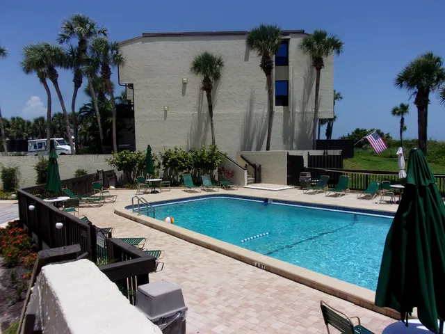 a view of a swimming pool with chairs and potted plants