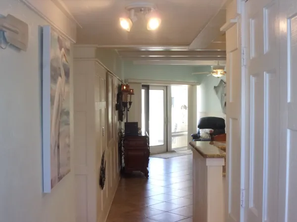 a hallway with a view of living room and wooden floor