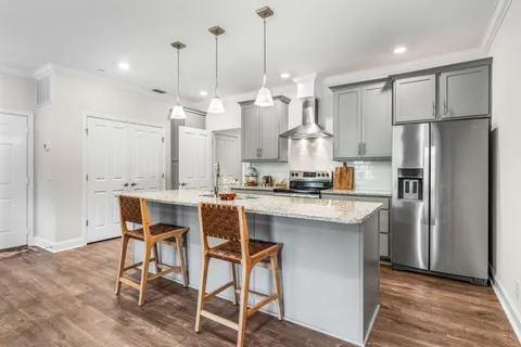 a kitchen with stainless steel appliances granite countertop a refrigerator a sink and a stove