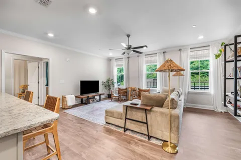 a living room with furniture a flat screen tv and a large window