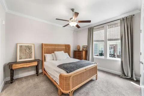 a bedroom with a bed and a chandelier fan