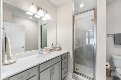 a bathroom with a sink a toilet and shower