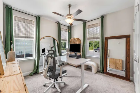 a work room with furniture a chandelier and a large window