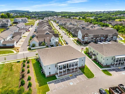 an aerial view of residential houses with outdoor space and ocean view