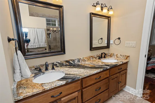 a bathroom with a granite countertop sink and a toilet