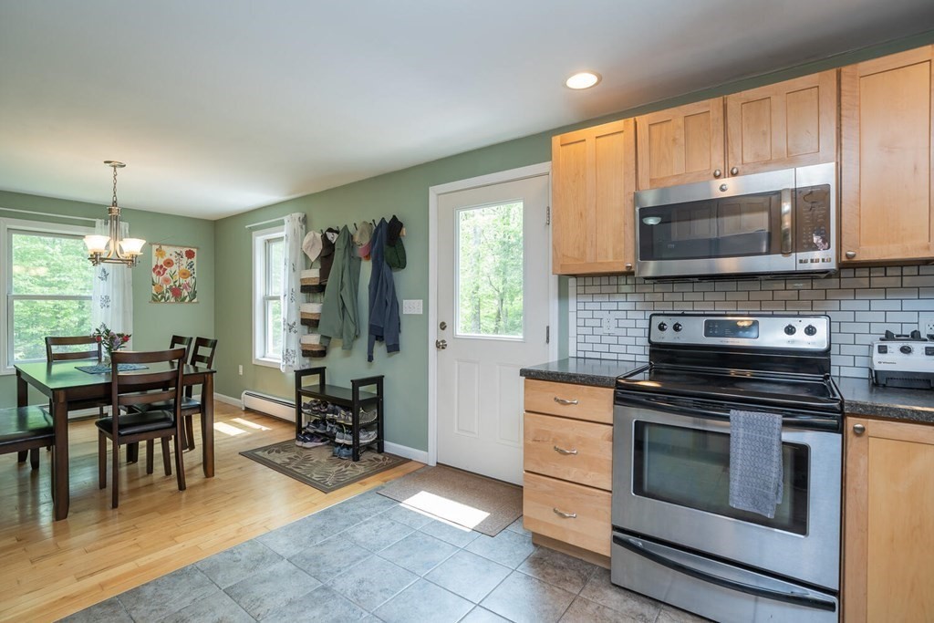 4 Highland Road Williamsburg, MA 01096 - Photo 15 of 42 a kitchen with granite countertop a stove top oven a sink a dining table and chairs