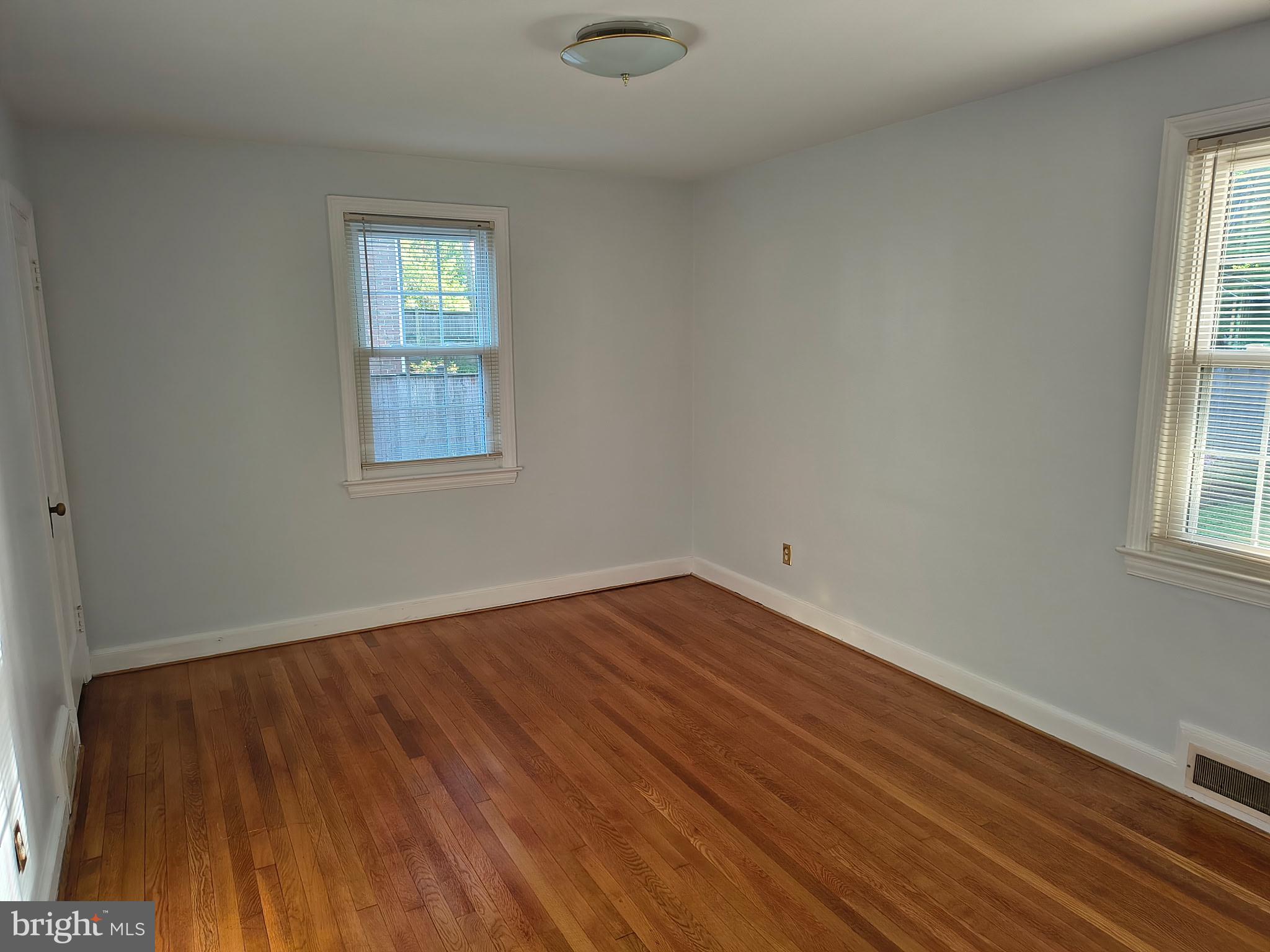 9316 Sudbury Road Silver Spring, MD 20901 - Photo 4 of 19 an empty room with wooden floor and windows
