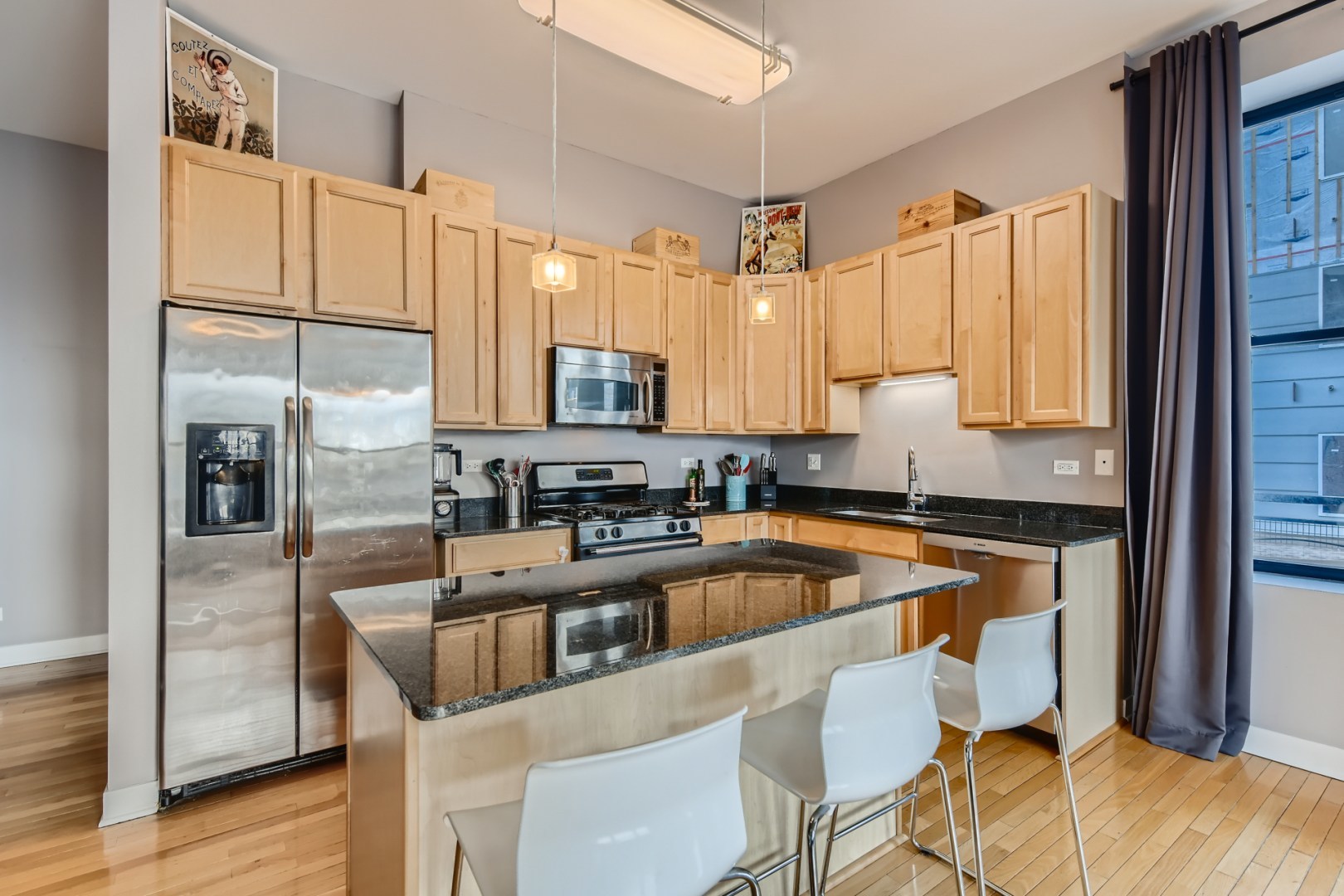 1 South Leavitt Street, Unit 307 Chicago, IL 60612 - Photo 9 of 23 a kitchen with stainless steel appliances granite countertop a stove a sink refrigerator and a microwave