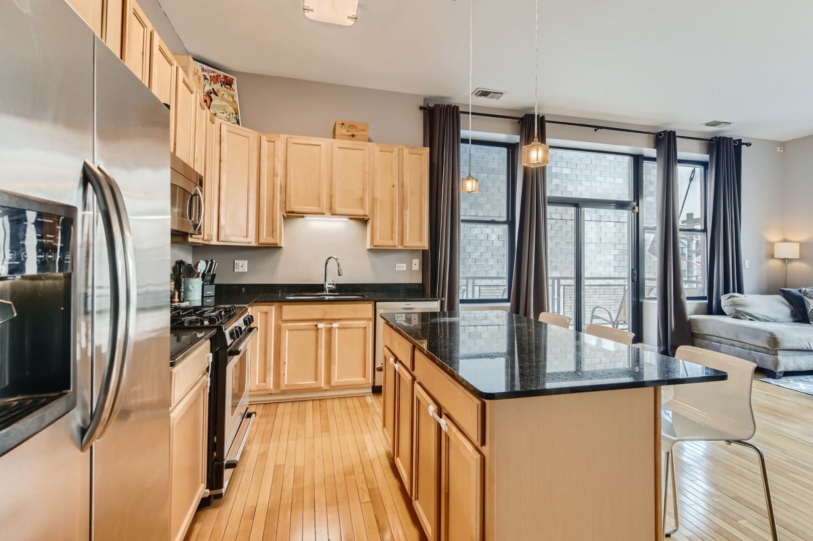 1 South Leavitt Street, Unit 307 Chicago, IL 60612 - Photo 10 of 23 a kitchen with stainless steel appliances granite countertop a refrigerator a stove and a sink with wooden floor