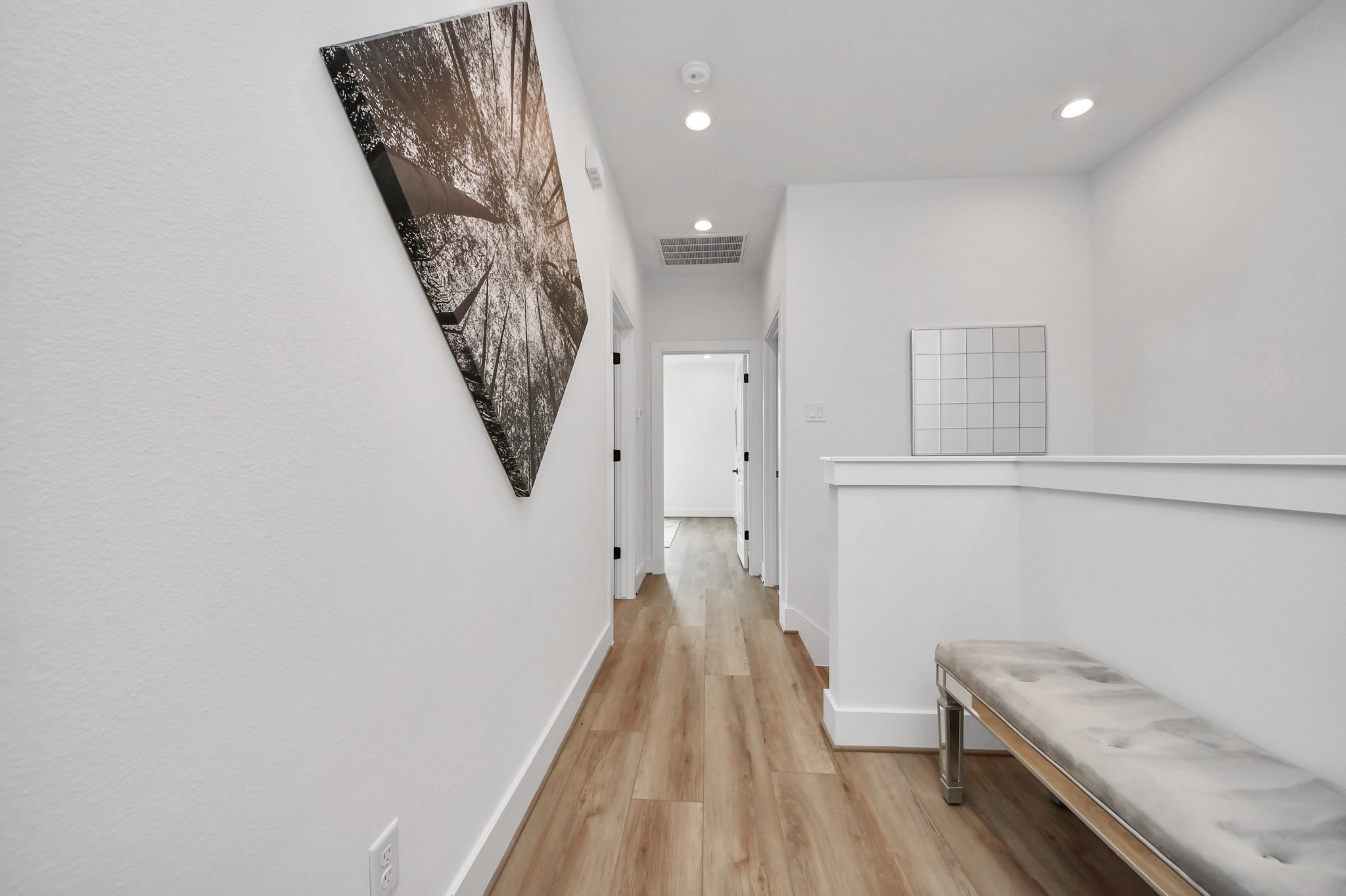 507 Middle Street Houston, TX 77003 - Photo 19 of 48 Discover the inviting second floor, featuring a sleek hallway with stylish wood flooring, modern art, and ample natural light, promising a serene and welcoming atmosphere.