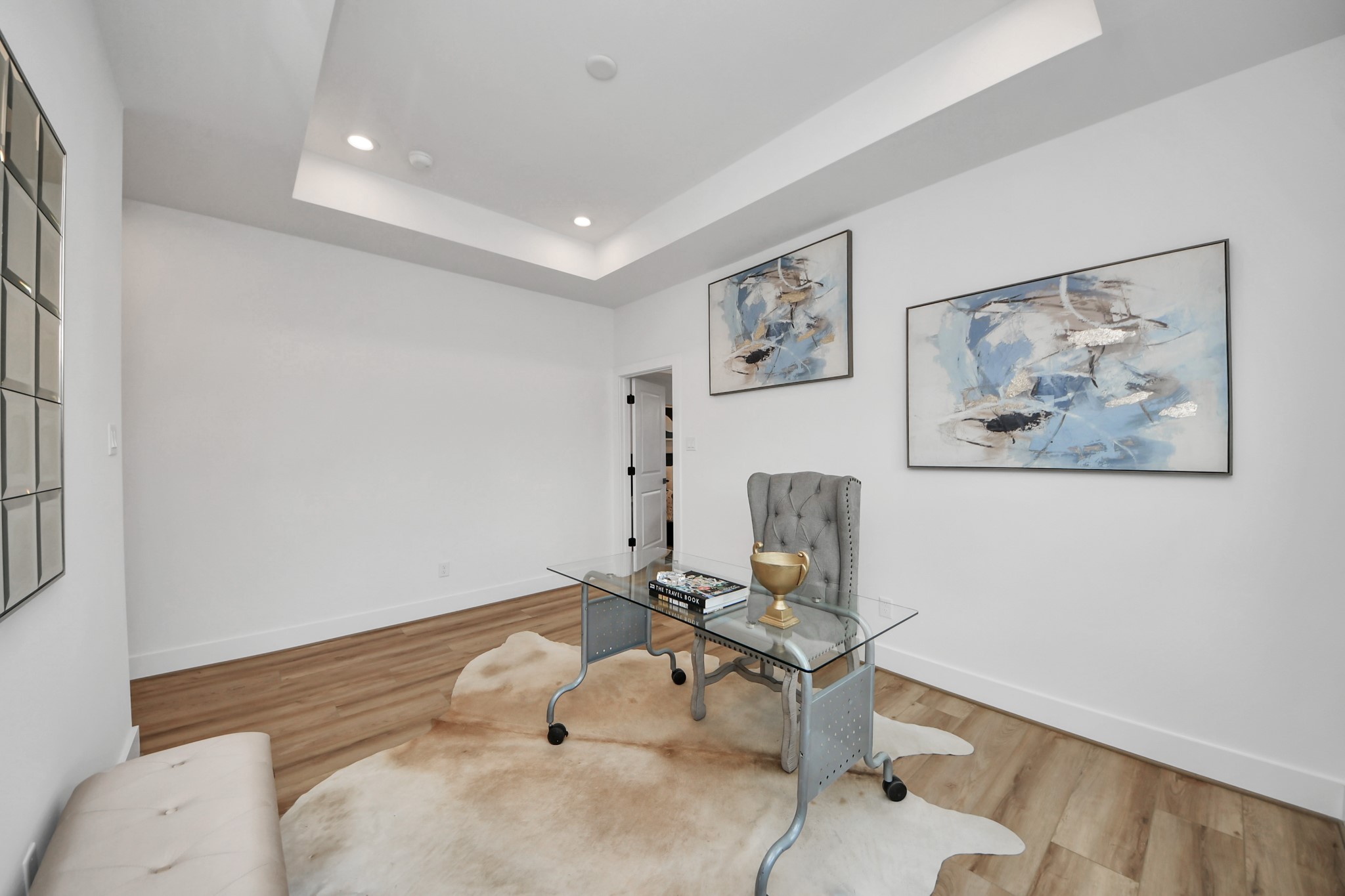 507 Middle Street Houston, TX 77003 - Photo 22 of 48 This bright and elegant office space features a sleek glass desk, warm wood flooring, and modern art, creating a perfect blend of style and functionality for inspired productivity.