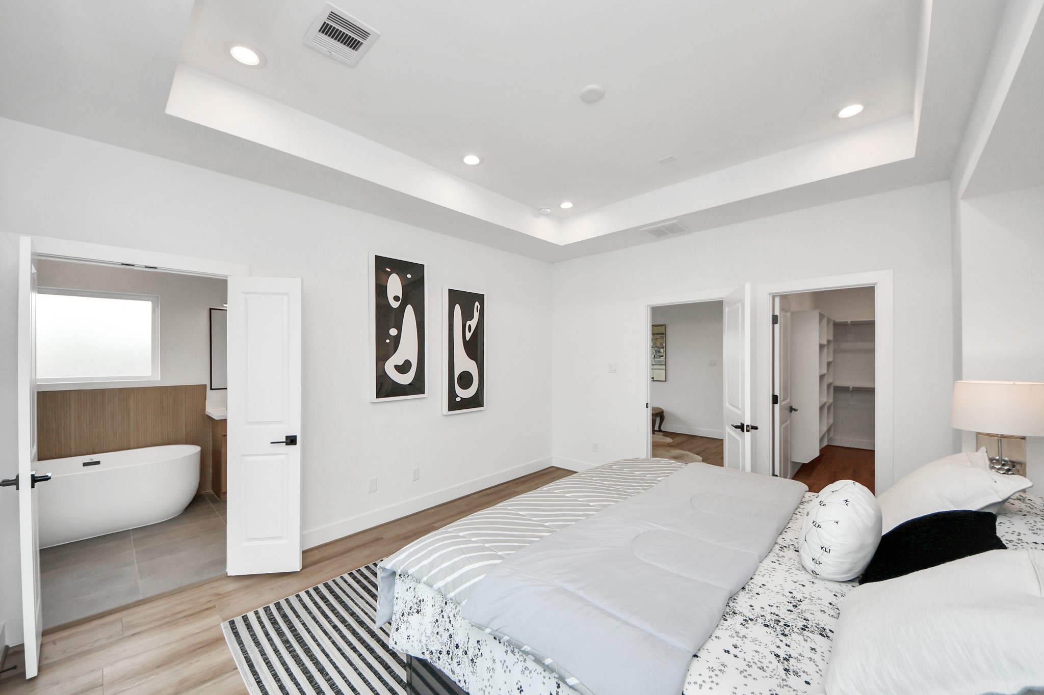 507 Middle Street Houston, TX 77003 - Photo 27 of 48 Experience luxury in this spacious primary bedroom featuring elegant tray ceilings, modern recessed lighting, and seamless access to a chic ensuite bathroom and expansive walk-in closet.