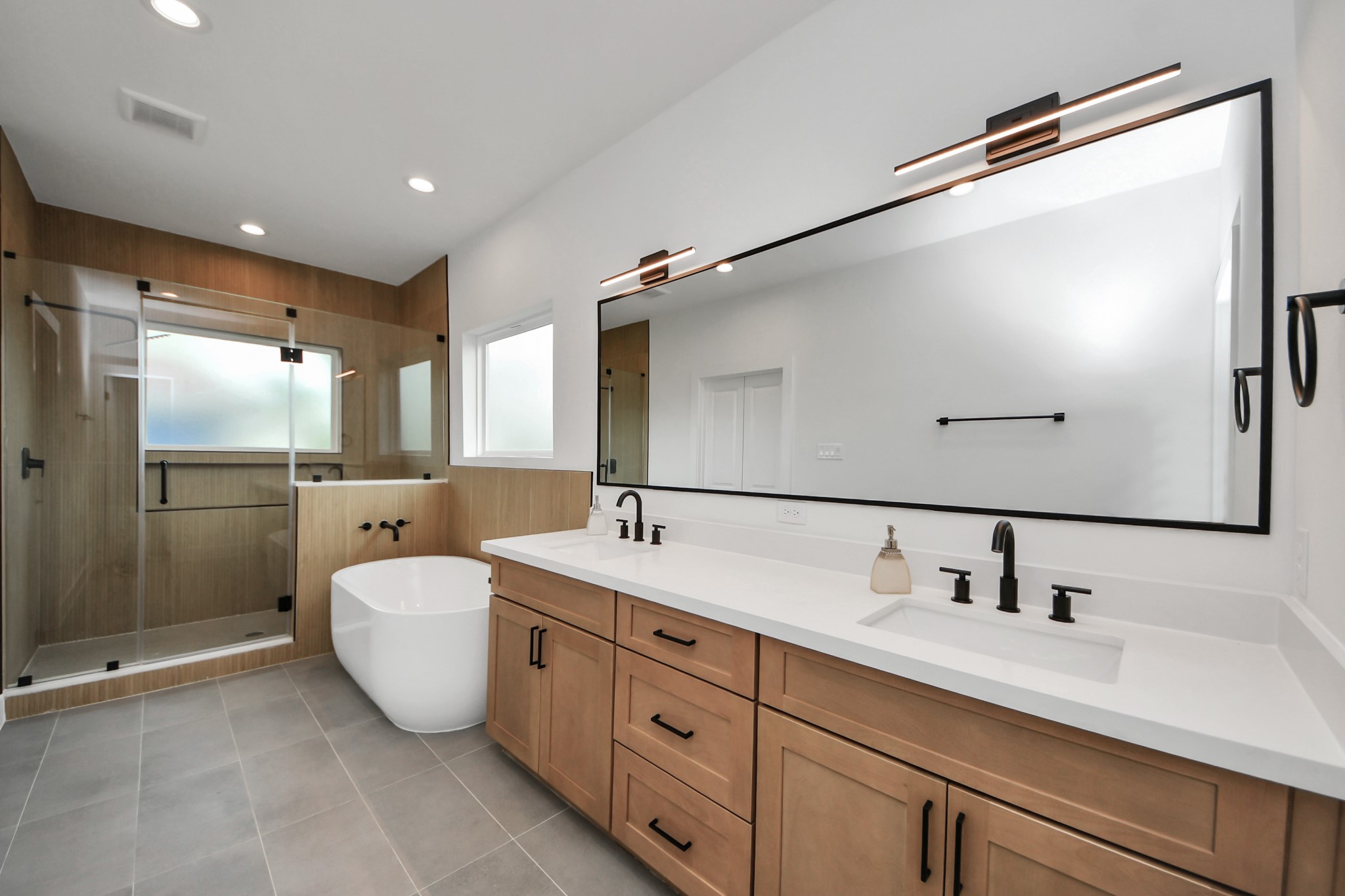 507 Middle Street Houston, TX 77003 - Photo 28 of 48 This stunning primary bathroom features a spacious layout with a sleek double vanity, luxurious soaking tub, and a modern glass-enclosed shower, offering a perfect blend of style and comfort.