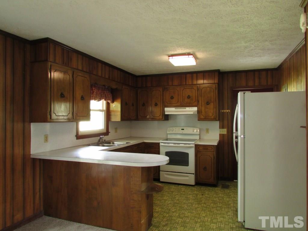 3749 Semora Road Roxboro, NC 27574 - Photo 4 of 24 Kitchen has custom cabinets and spacious bar for food prep. Appliances convey