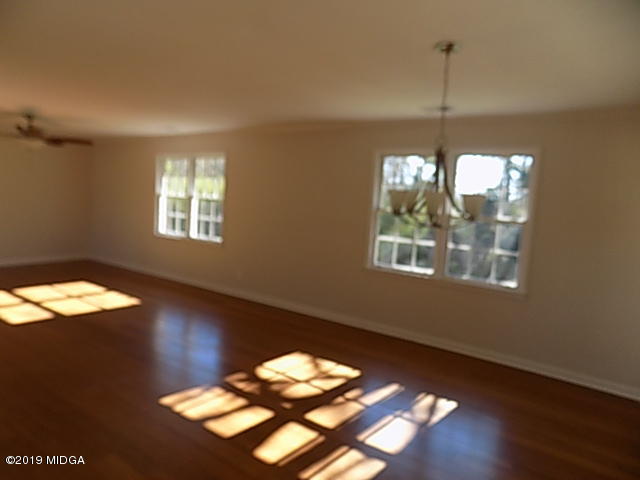 7940 Bethel Church Road Lizella, GA 31052 - Photo 14 of 34 a view of an empty room with wooden floor and windows