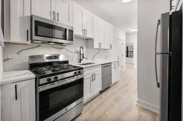 a kitchen with stainless steel appliances a stove microwave and sink